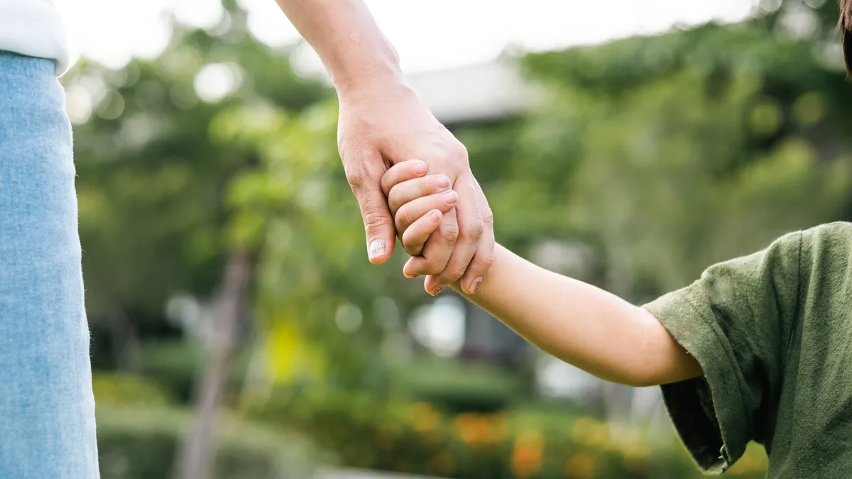 A parent and child walking hand in hand